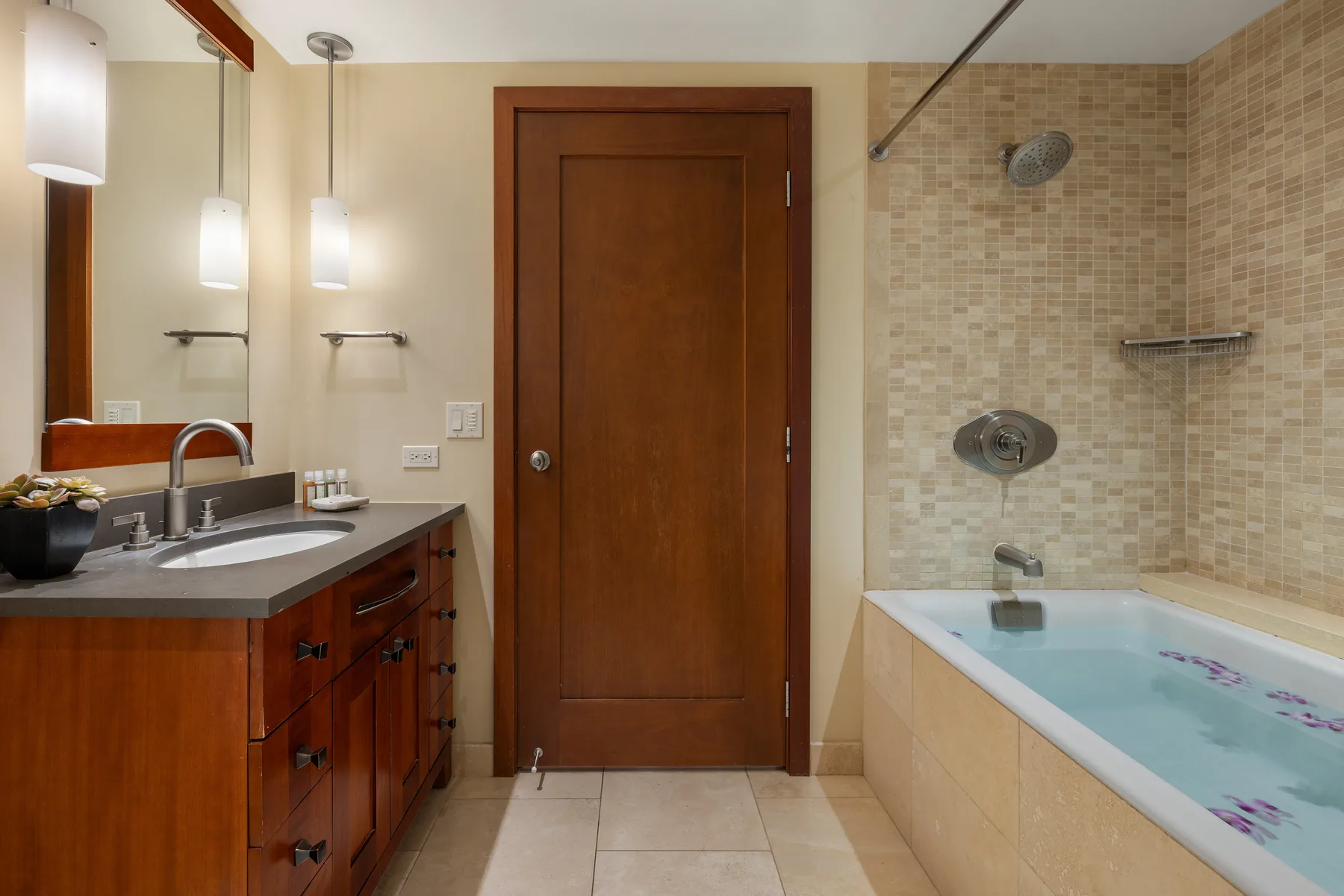 Un baño con un tocador junto a una bañera y ducha con azulejos.
