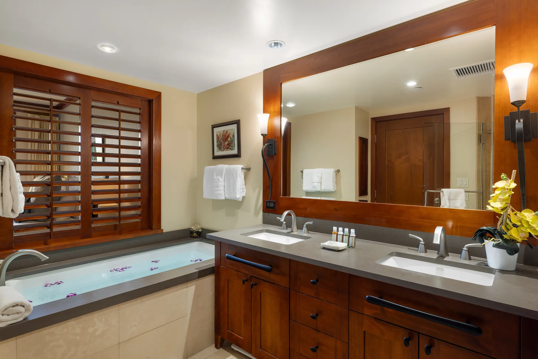 Un lavabo de baño con un espejo grande está junto a una bañera empotrada.