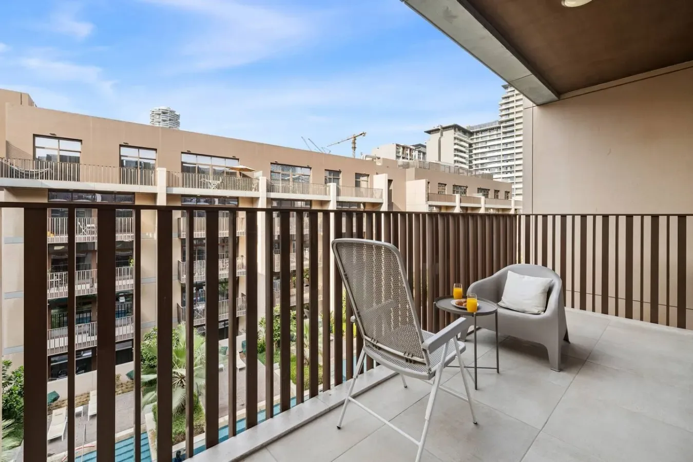Una zona de descanso en el balcón tiene vistas a edificios de apartamentos cercanos.