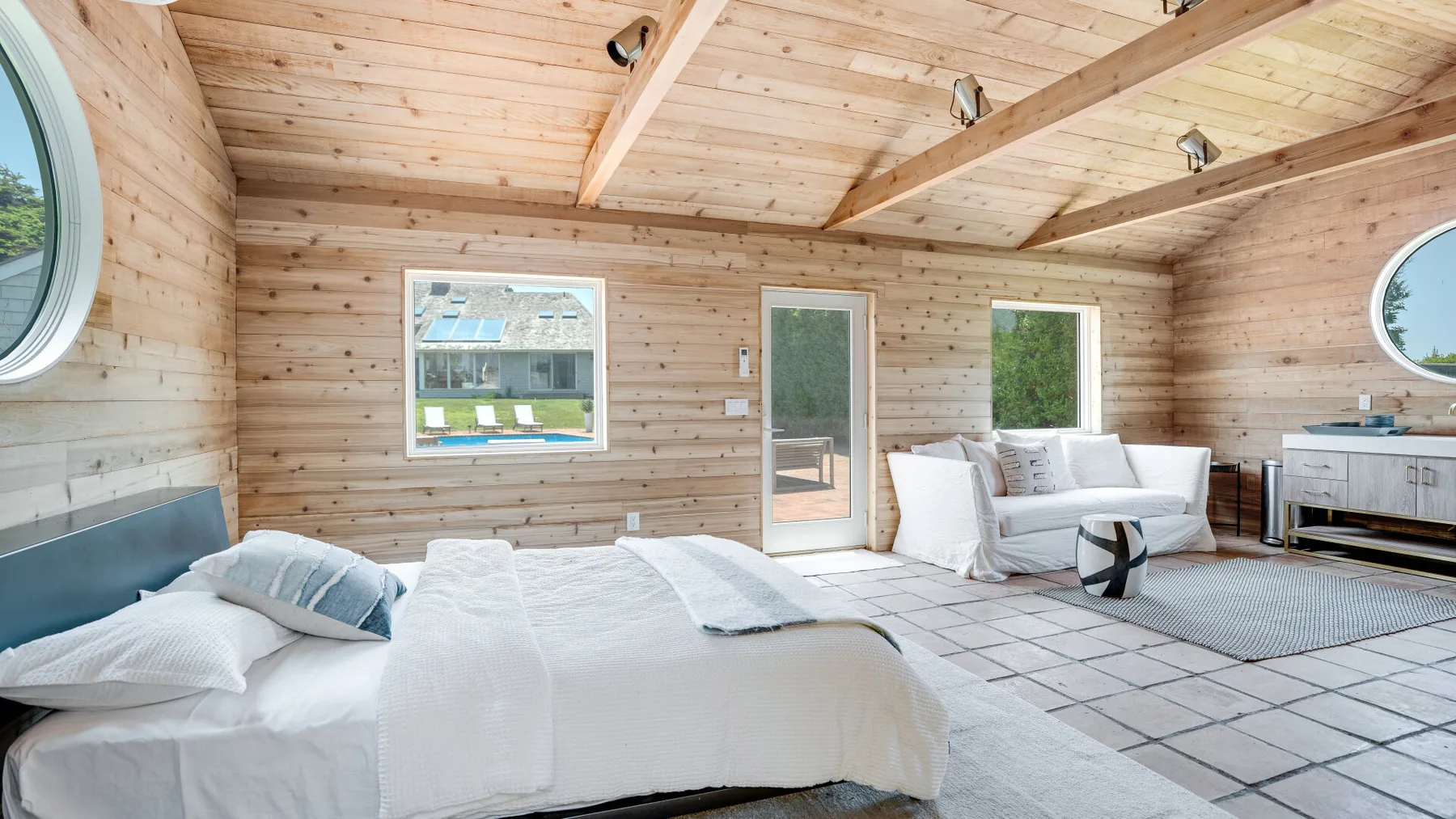 A wood-paneled bedroom with a bed and a small seating area.