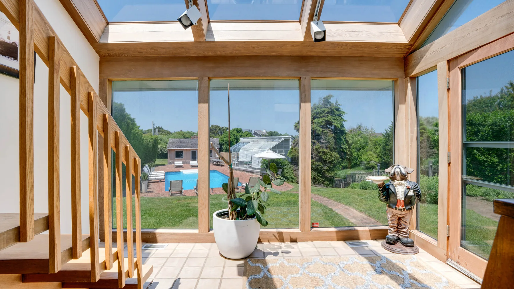 A bright sunroom with large windows overlooking a garden.