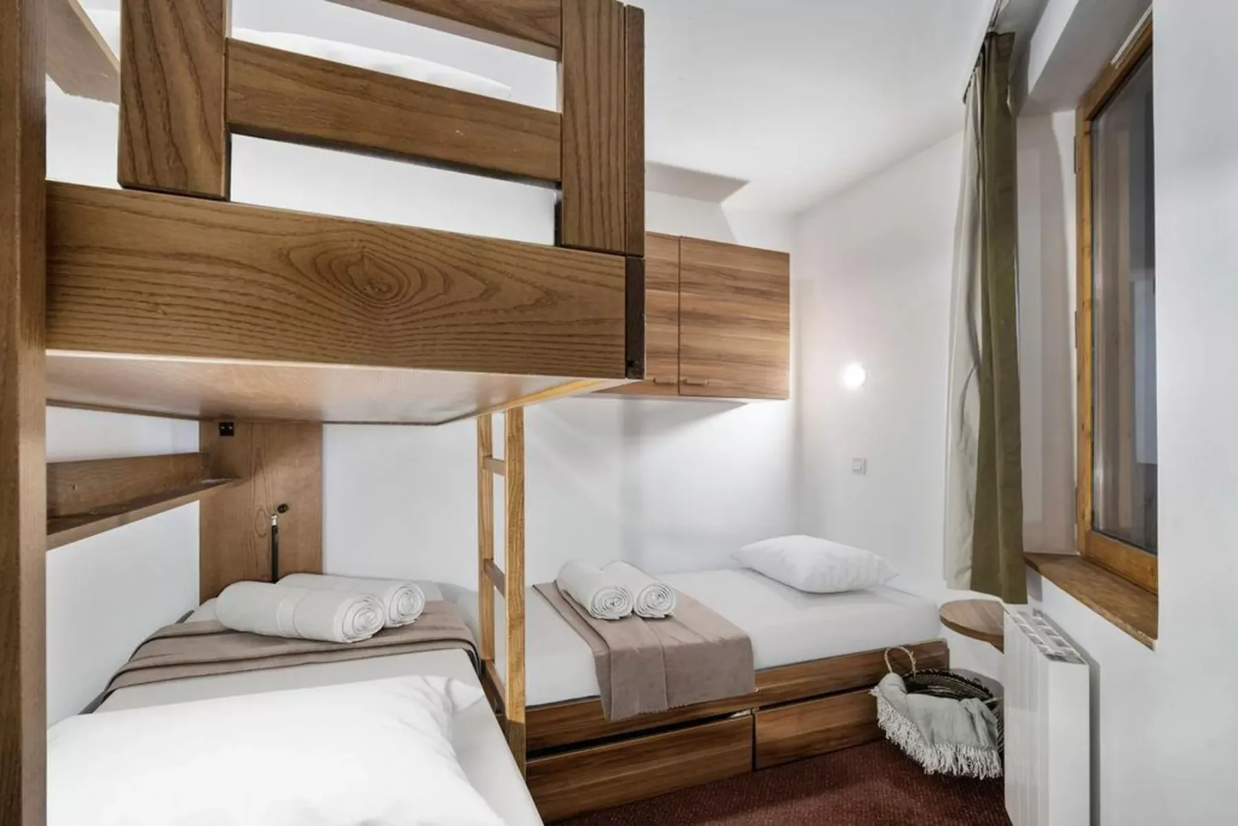 Un dormitorio con dos camas, muebles de madera y una ventana.
