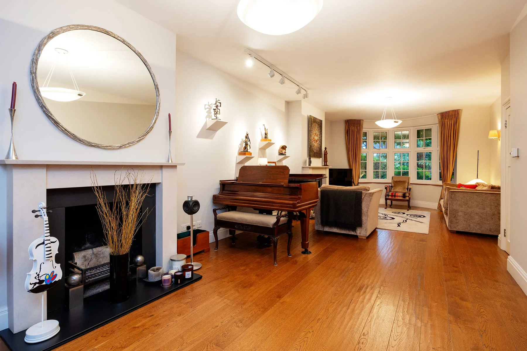 Una sala luminosa con piano, chimenea y zona de estar.