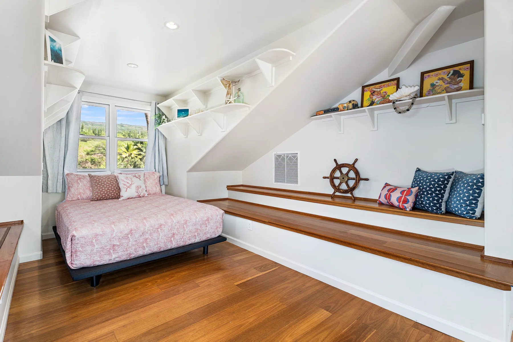 A bright bedroom with a bed beneath a sloped ceiling and a window.