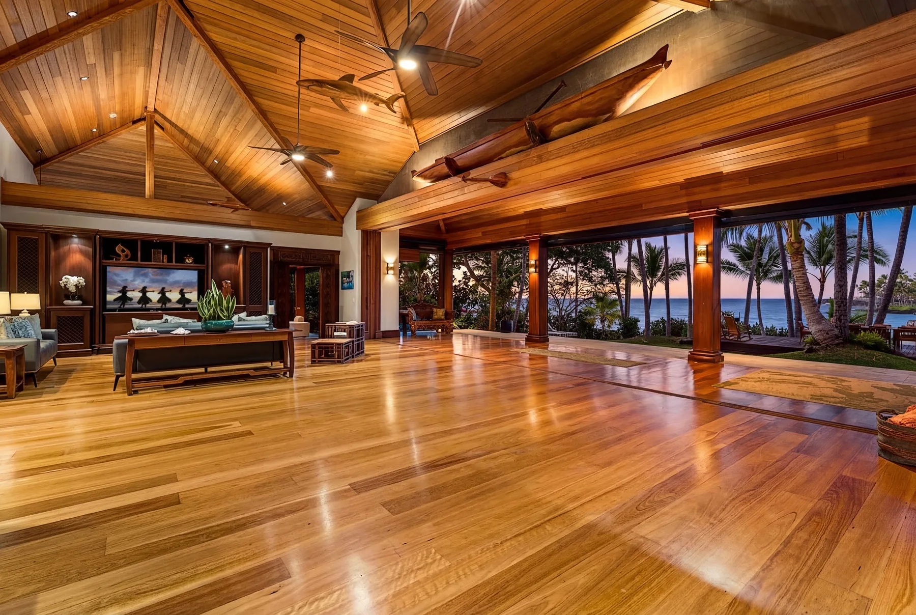 A spacious timber interior opens onto a tropical garden and ocean view.