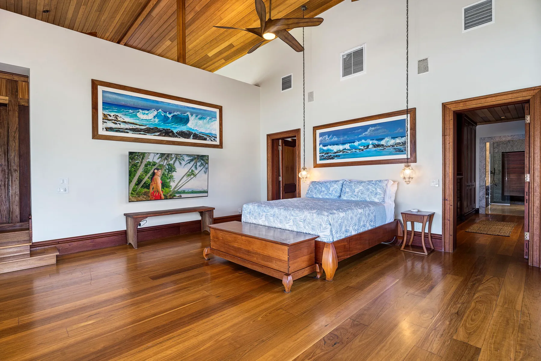 A bedroom with a bed, wooden flooring, and a sloped wood ceiling.