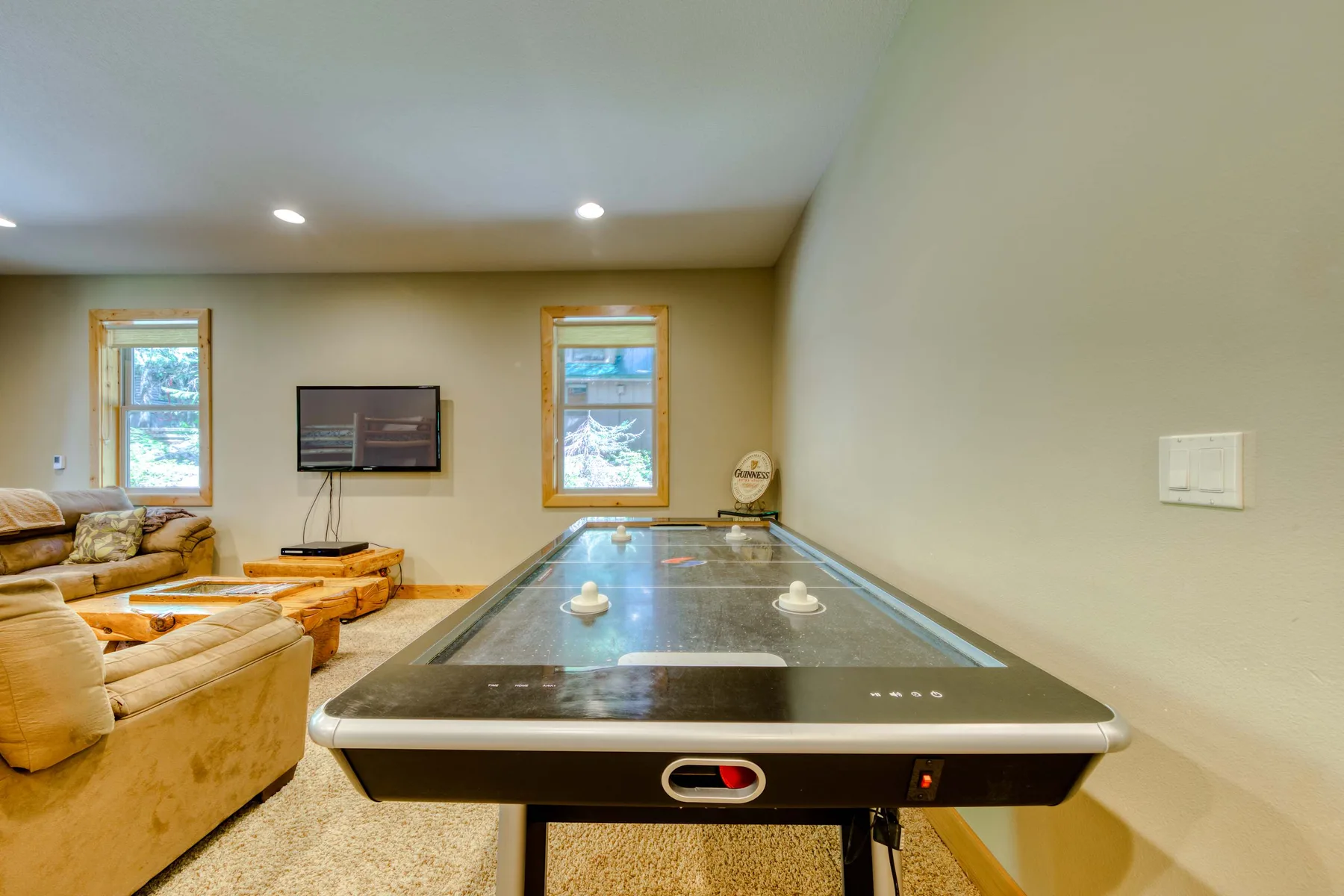 A game room features a pool table, seating, and a television.