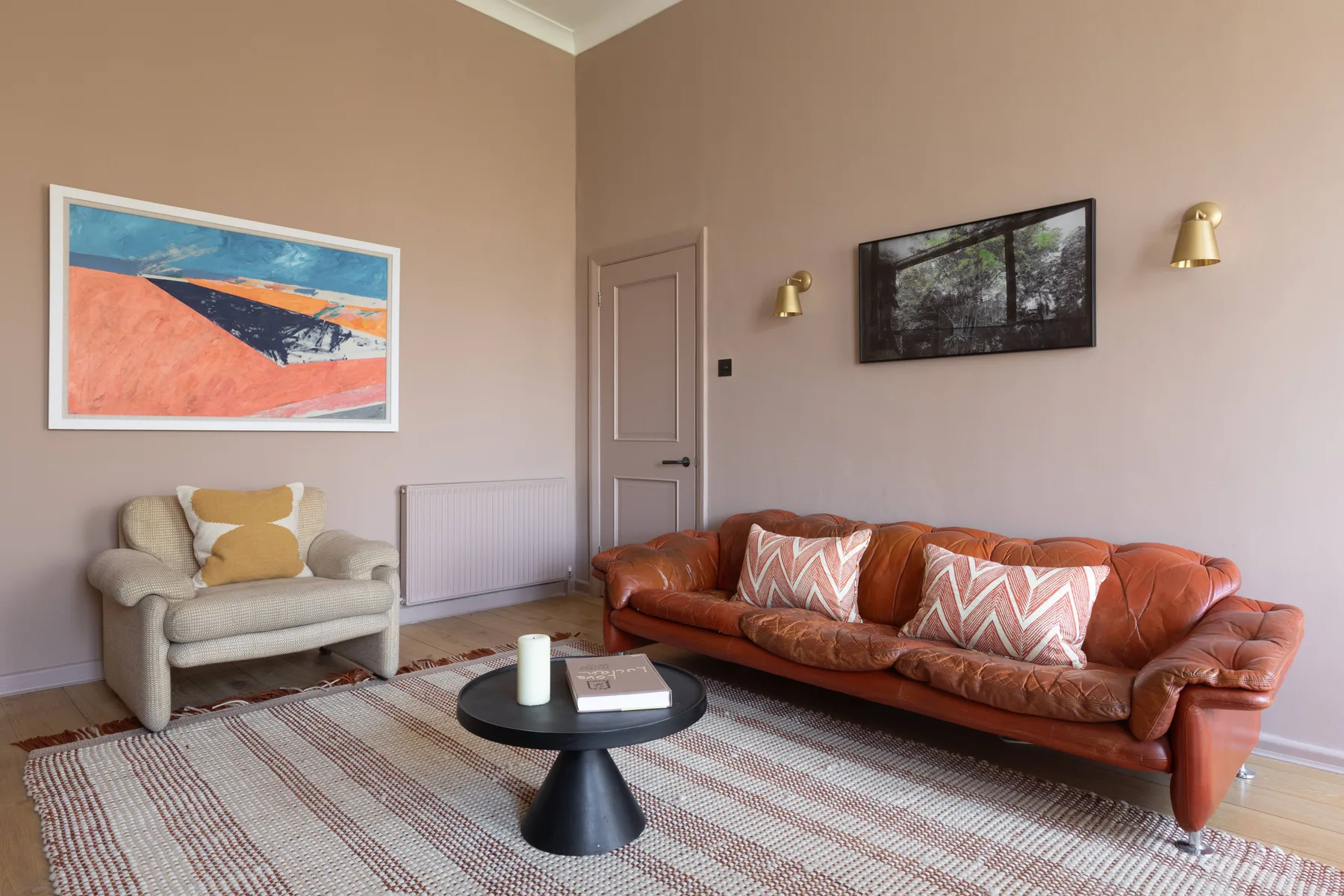 A living room with a leather sofa, an armchair, and a low coffee table.