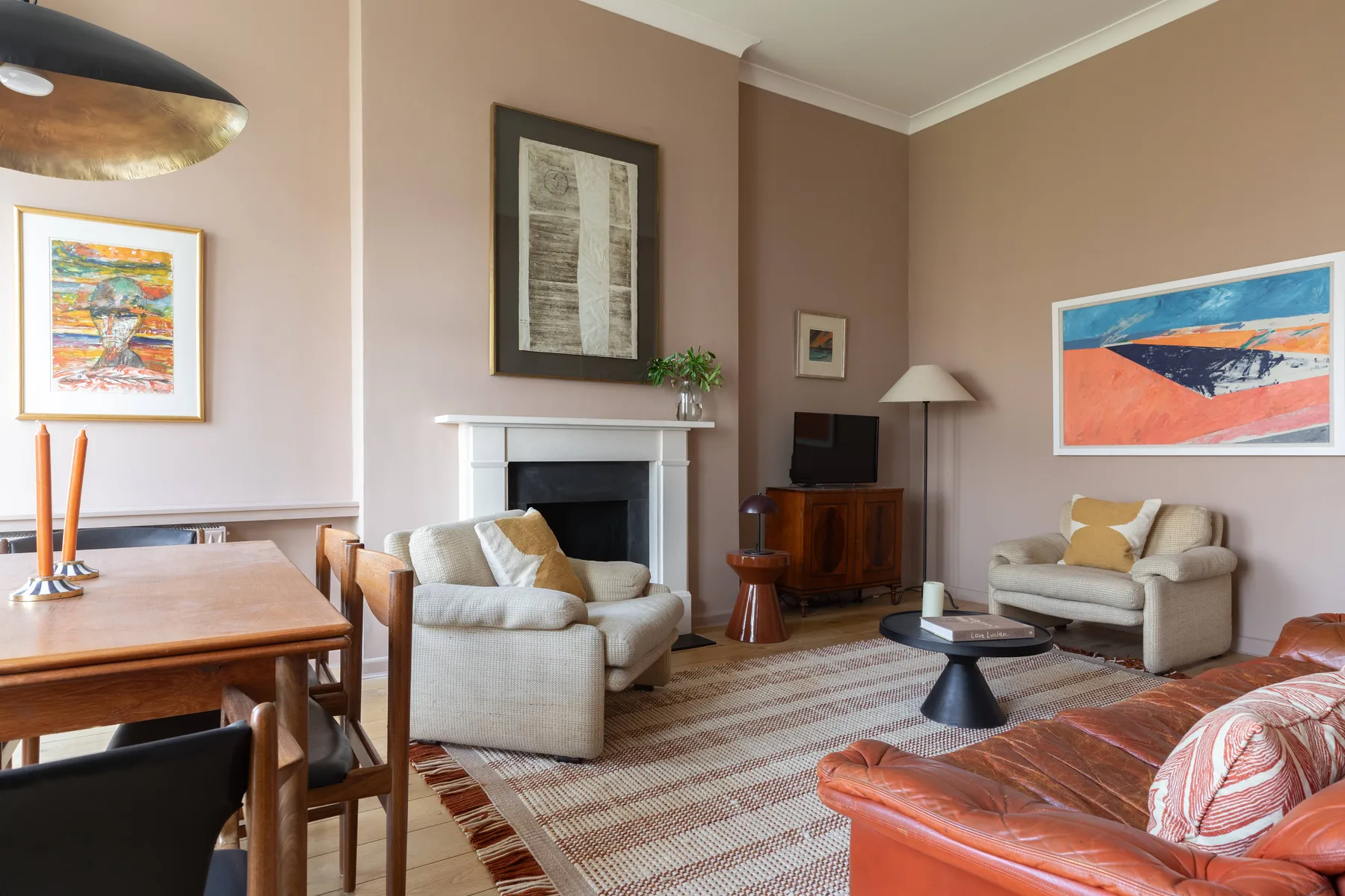 A living room with seating arranged around a fireplace and coffee table.