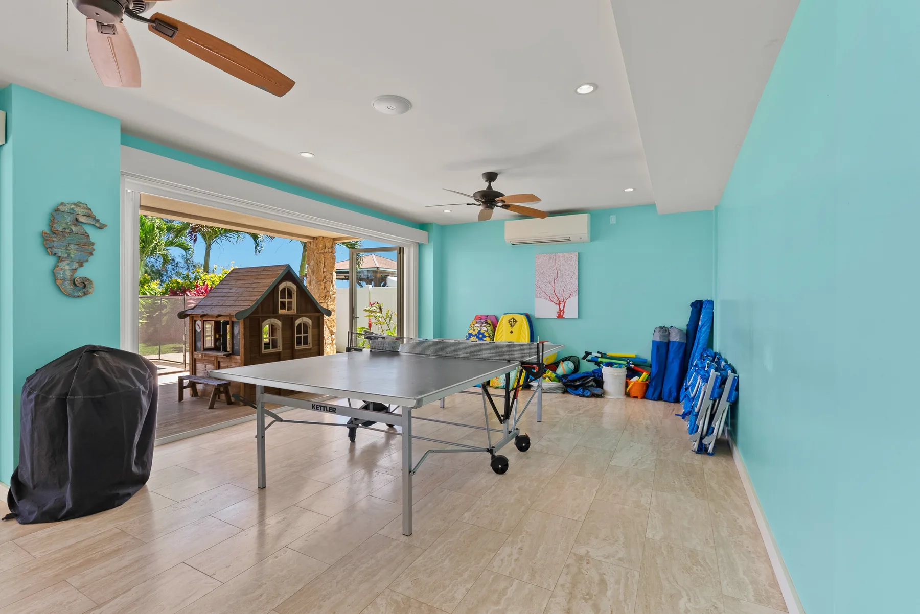 Una sala de recreación con una mesa de ping-pong y detalles coloridos en la pared.