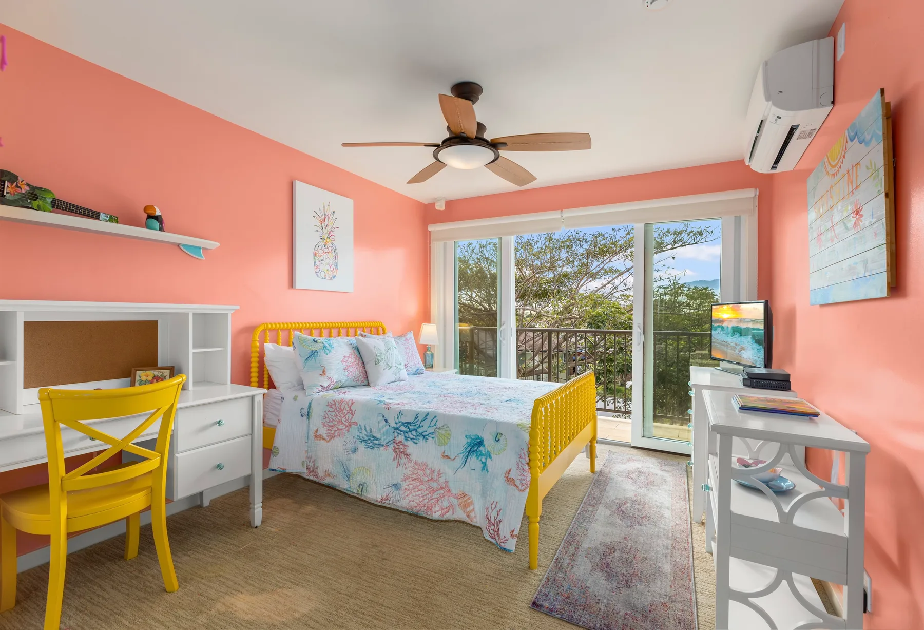Un dormitorio colorido con una cama junto a una gran puerta corrediza de vidrio.