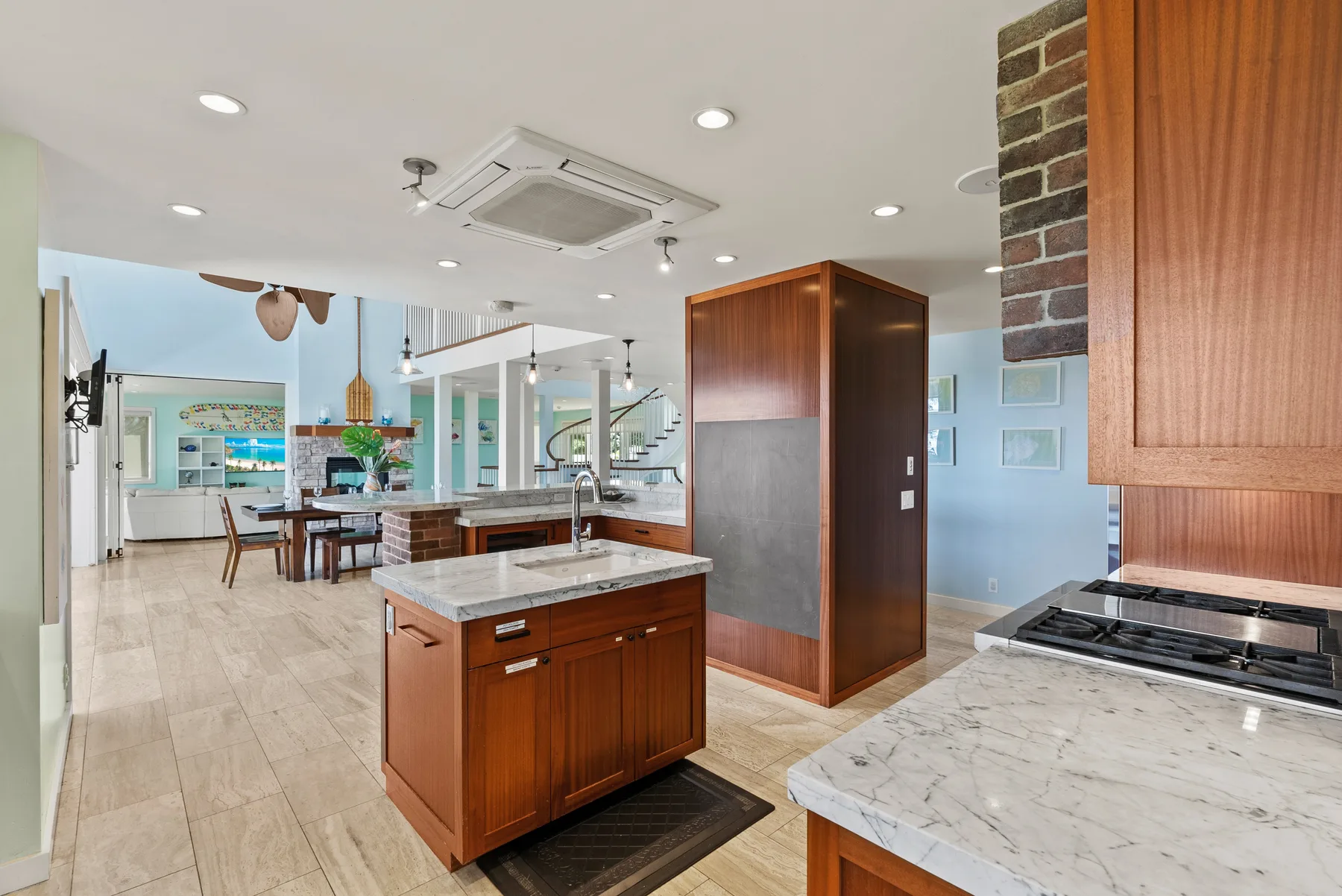 Una cocina luminosa con una isla central y un comedor contiguo.