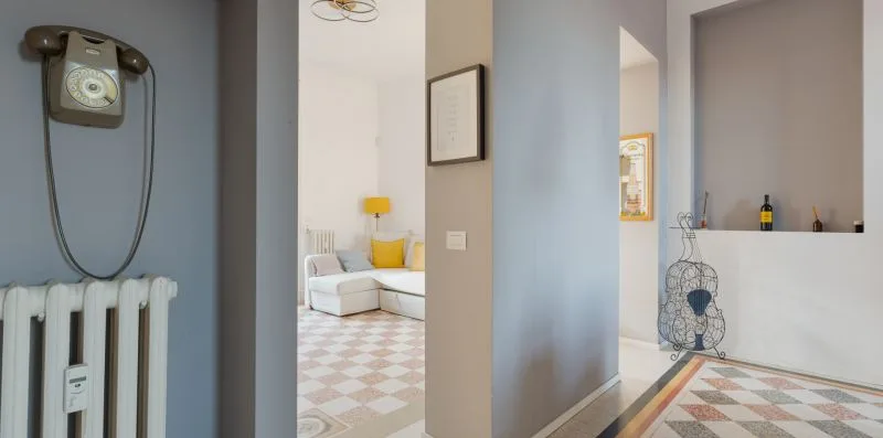 A hallway opens onto a tiled living area, with a radiator and wall-mounted telephone.