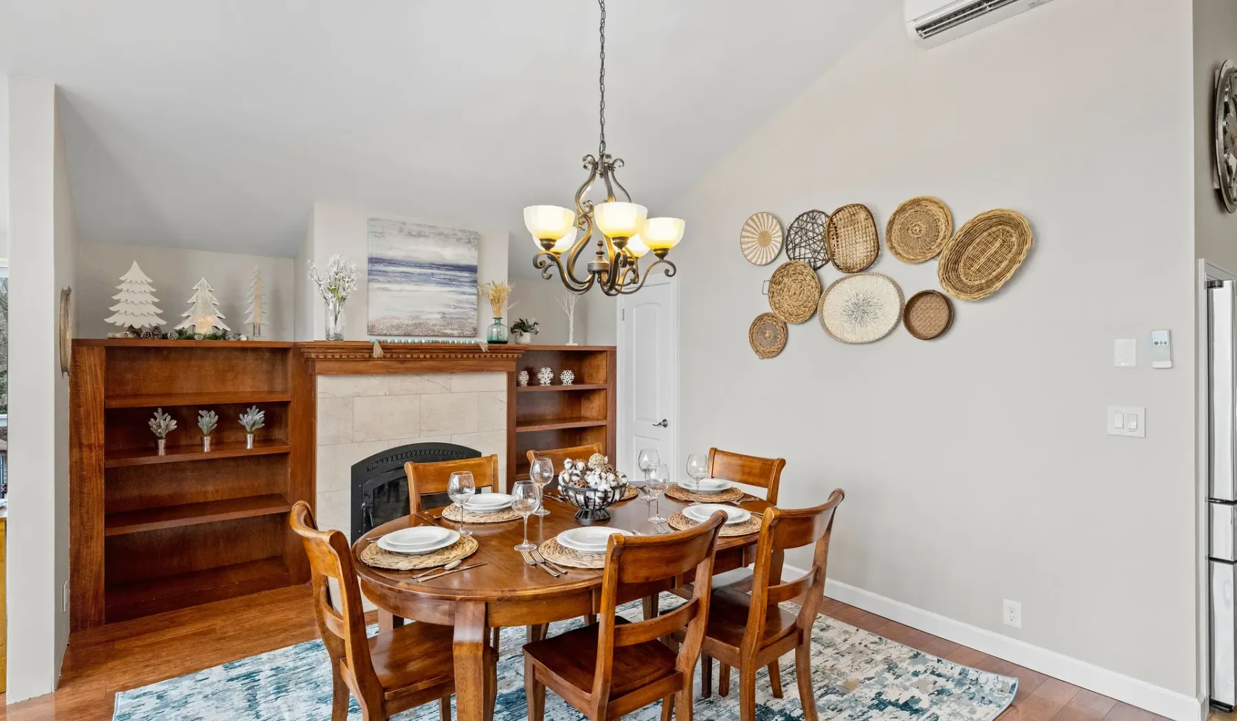 A dining room with a wooden table and chairs set for a meal.