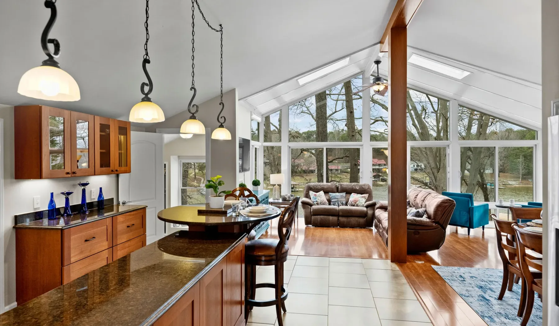 A bright open-plan living and dining area has large windows and a kitchen island.