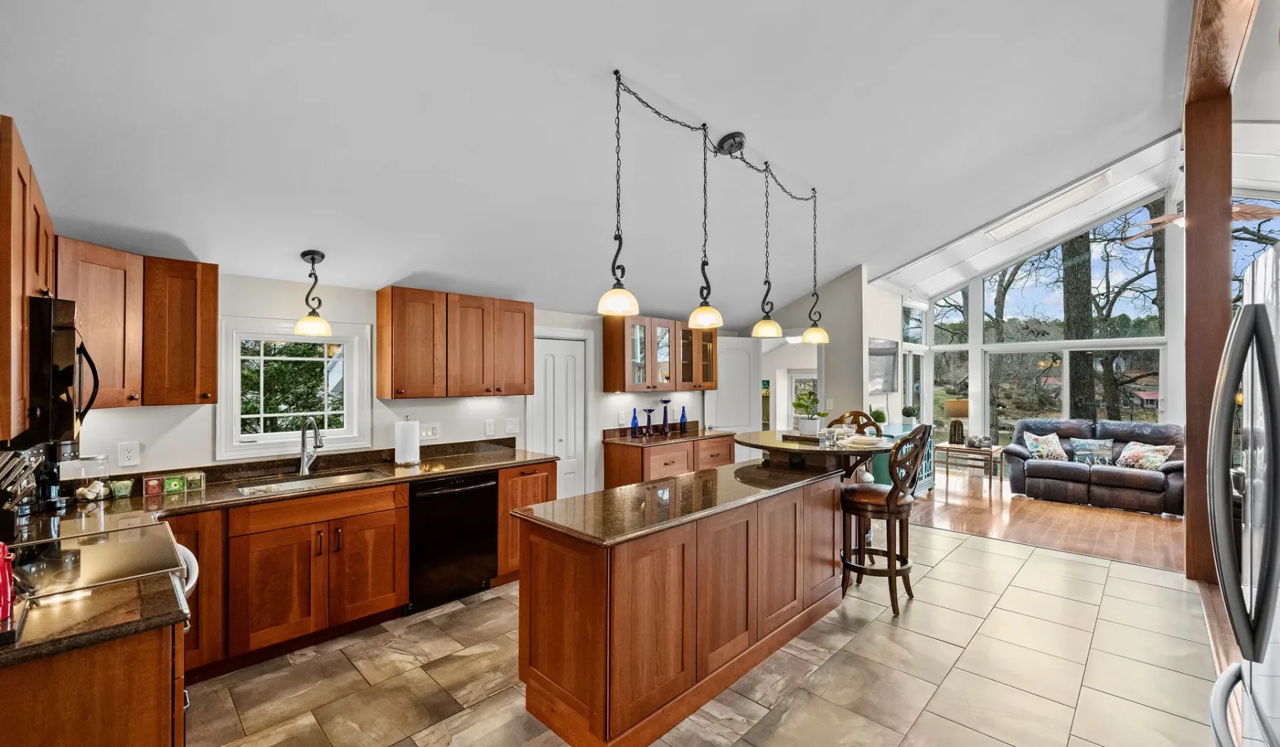 A spacious kitchen with a wooden island opens onto a bright living area.