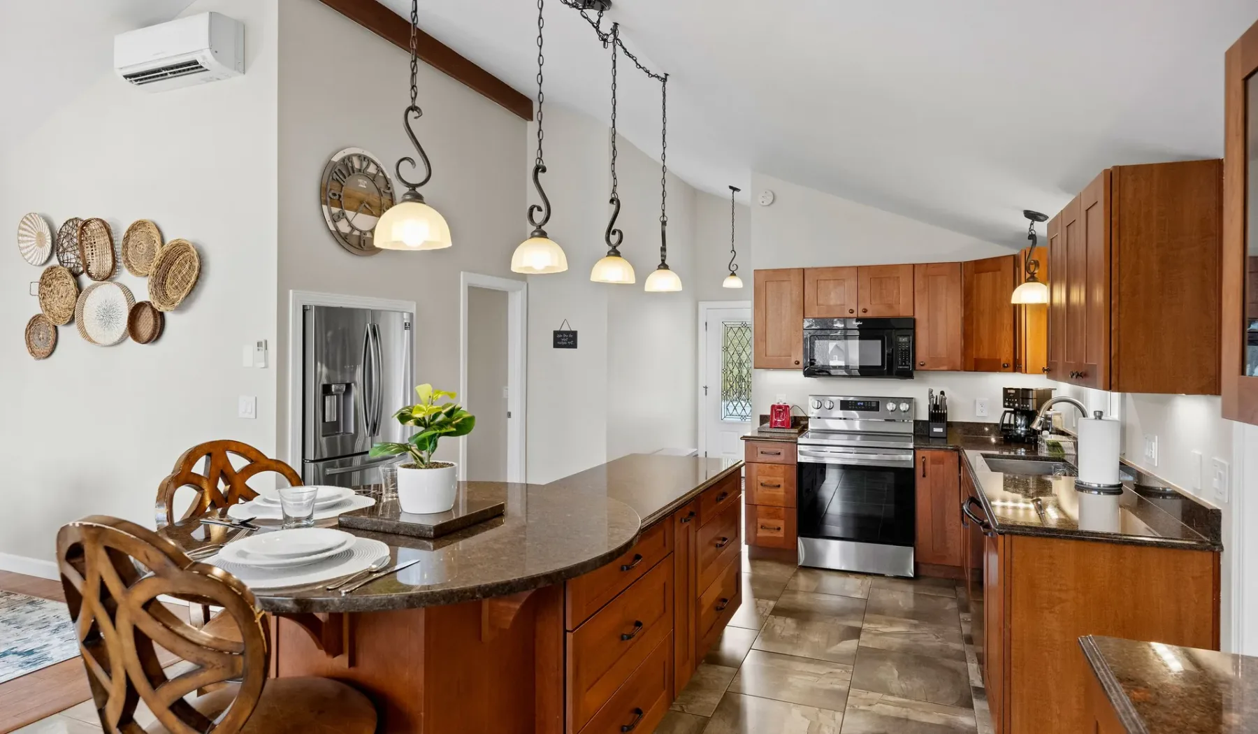 A kitchen with wooden cabinets, stainless steel appliances, and a dining counter.