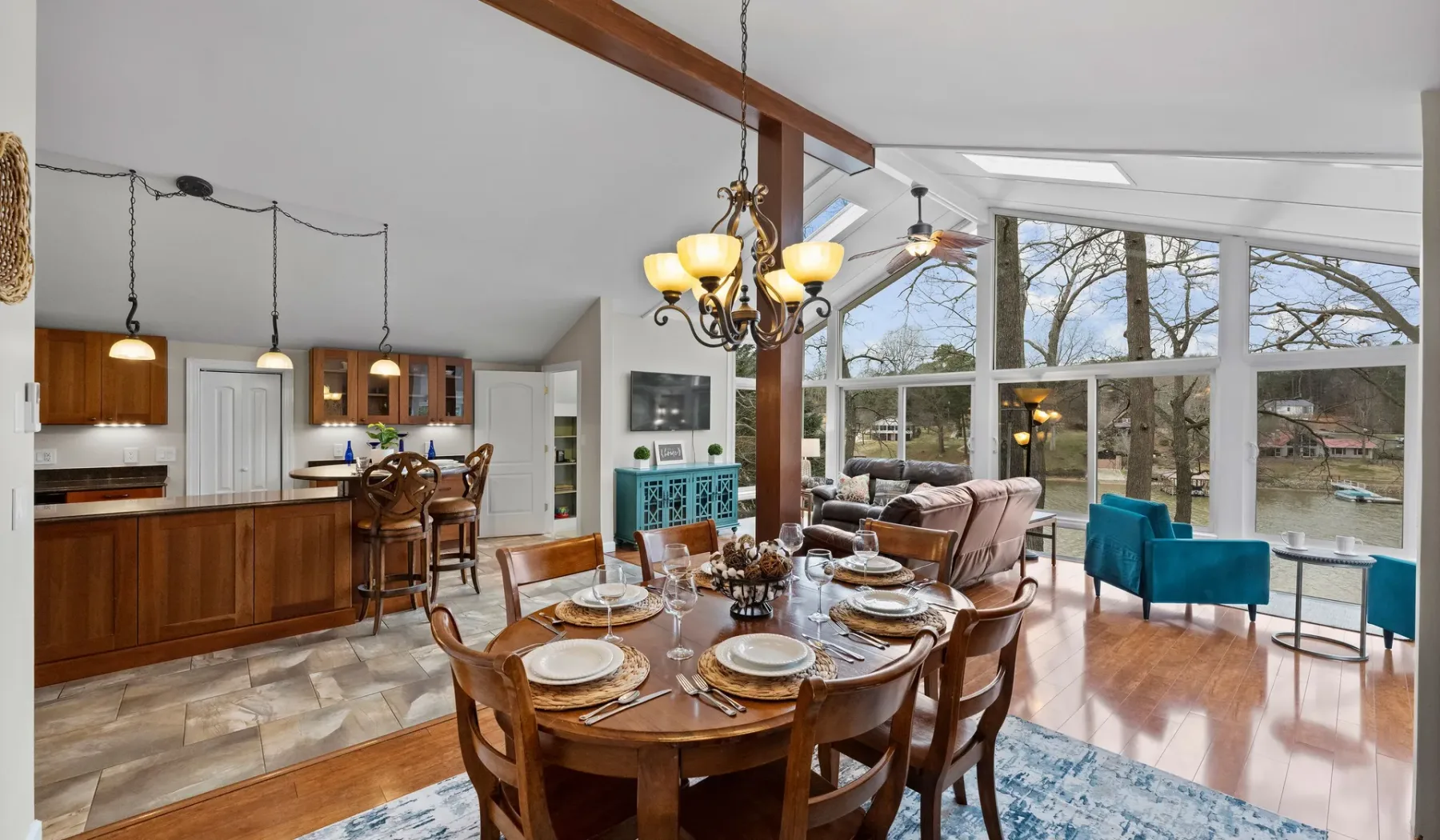 An open dining and living area with a kitchen and large windows.