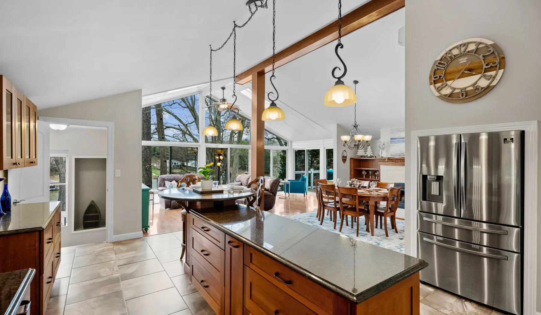 An open kitchen and dining area with a central island and large windows.