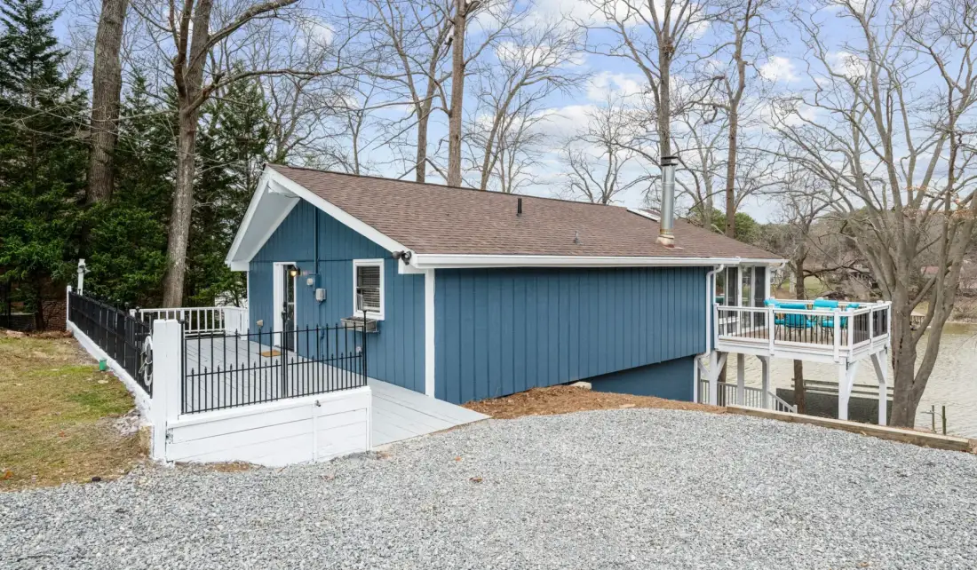 A blue building with a gravel area and fenced outdoor seating.
