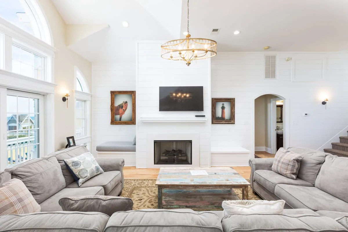 A bright living room with seating around a fireplace and coffee table.