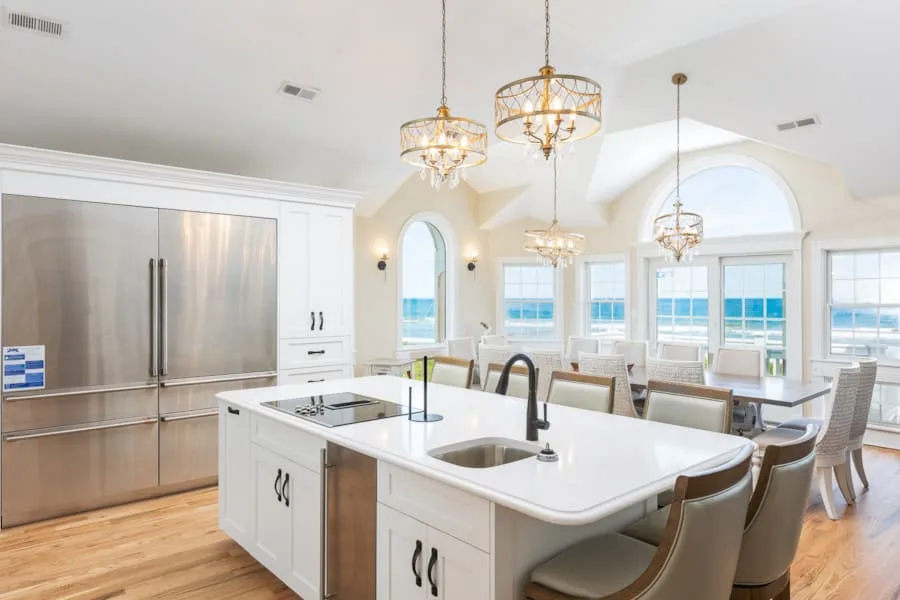 A bright kitchen with a large island and windows overlooking the water.