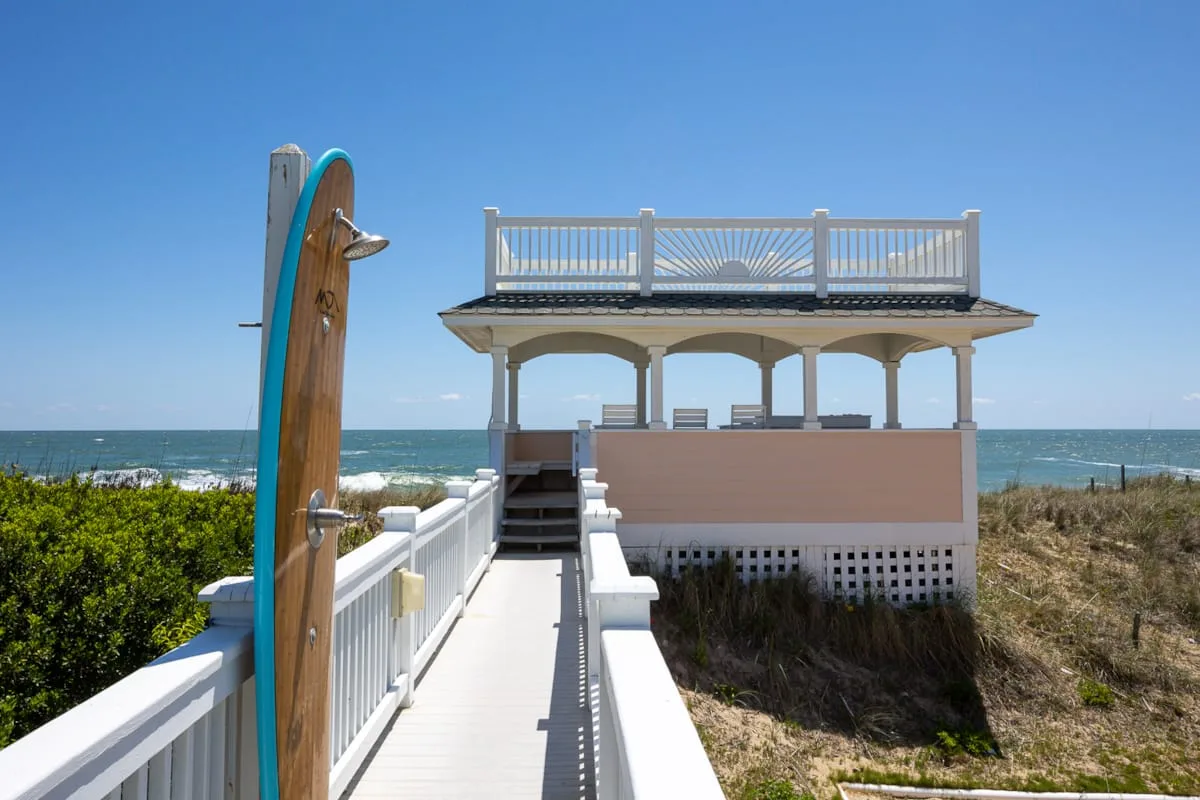 Una terraza elevada junto al mar mira al océano, con un paseo que conduce hasta ella.
