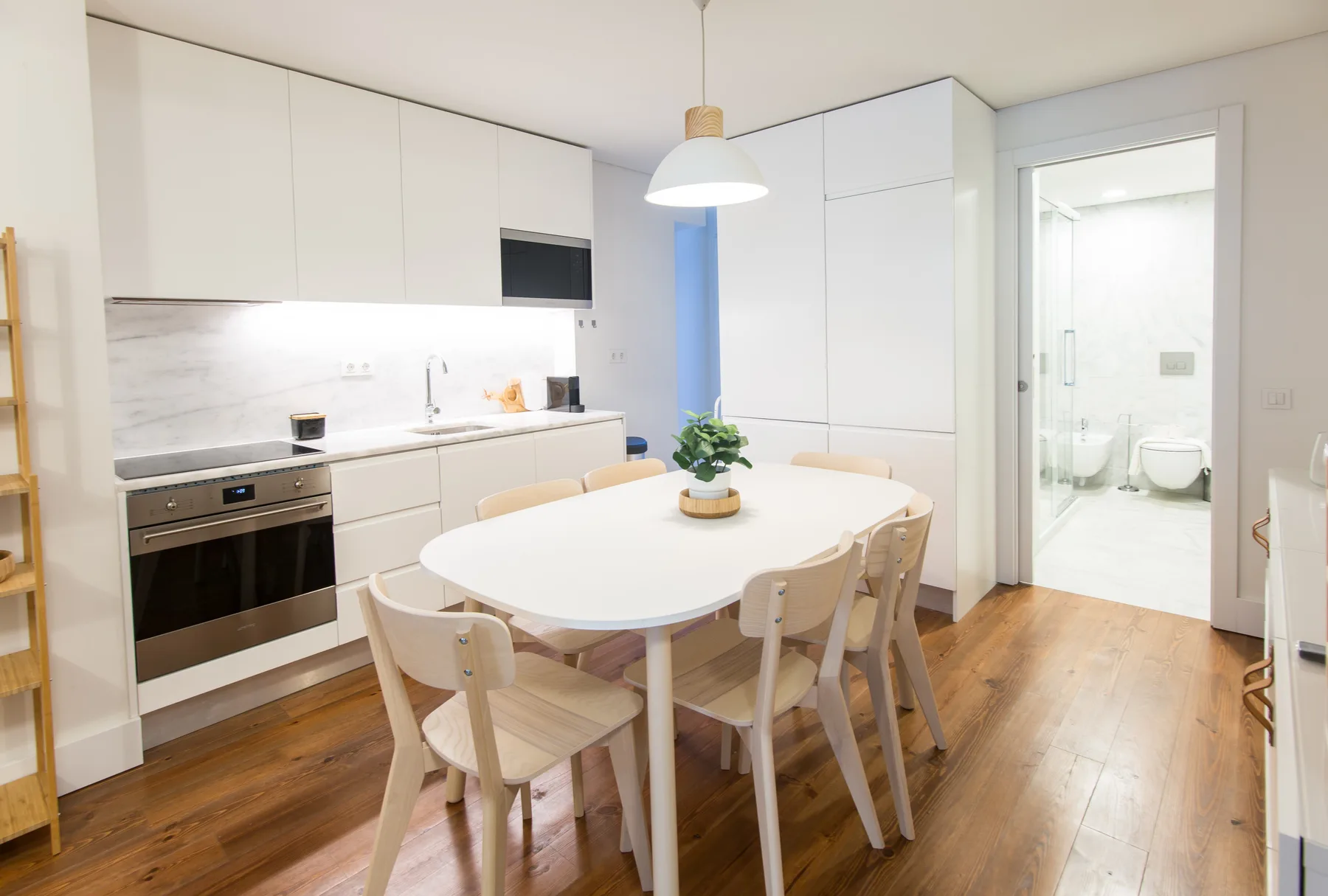 A bright kitchen and dining area with white cabinets and a table.