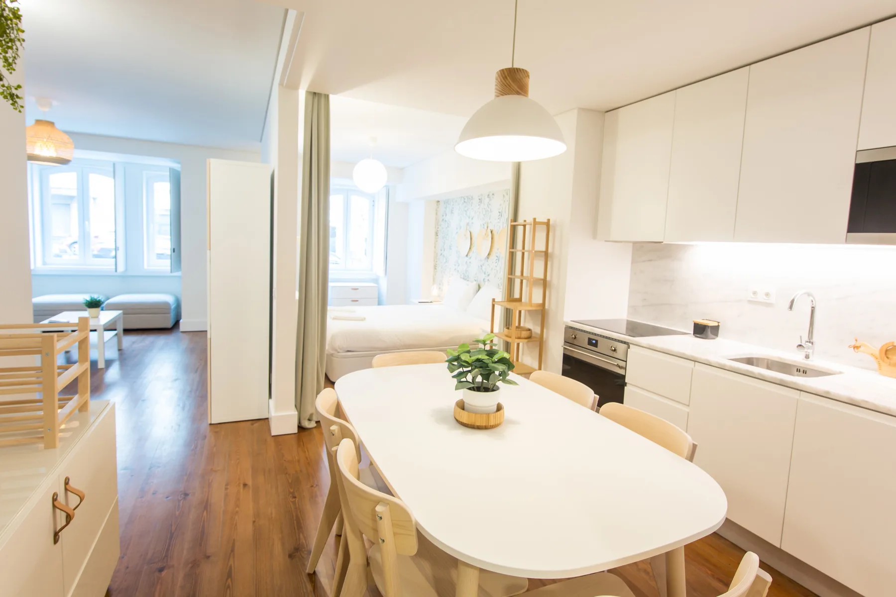A bright dining area and kitchen open onto a bedroom and sitting area.