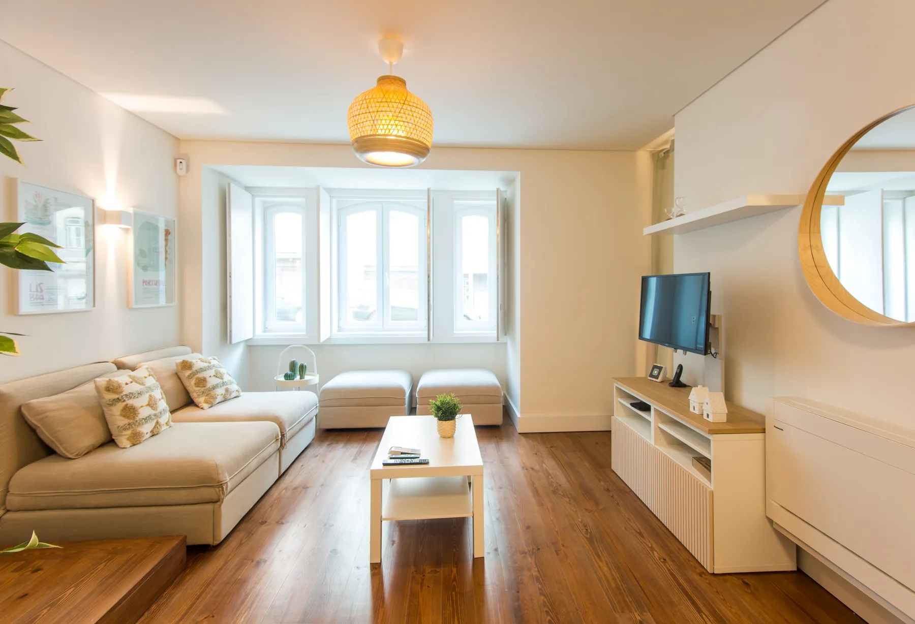 A bright living room with seating, a coffee table, and large windows.
