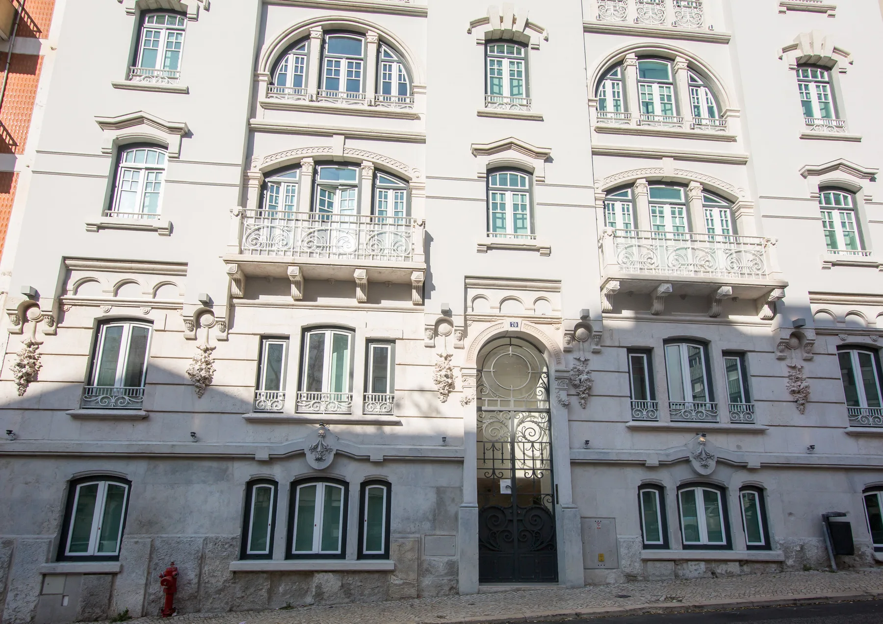 Street view of an ornate building facade with arched windows and balconies.