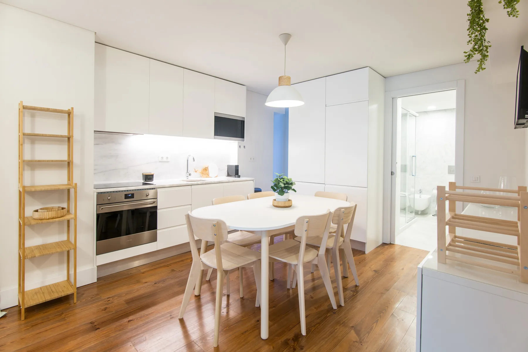 A bright kitchen and dining area with white cabinetry and a table.