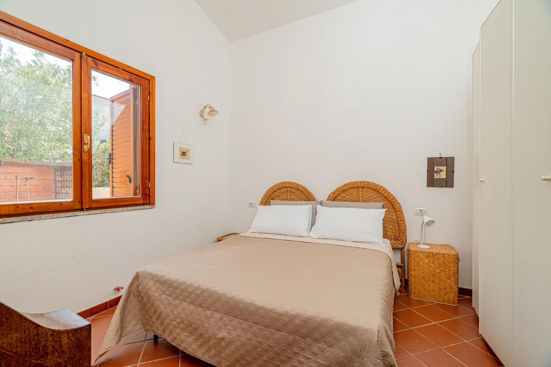 Un dormitorio con una cama bajo una ventana grande.