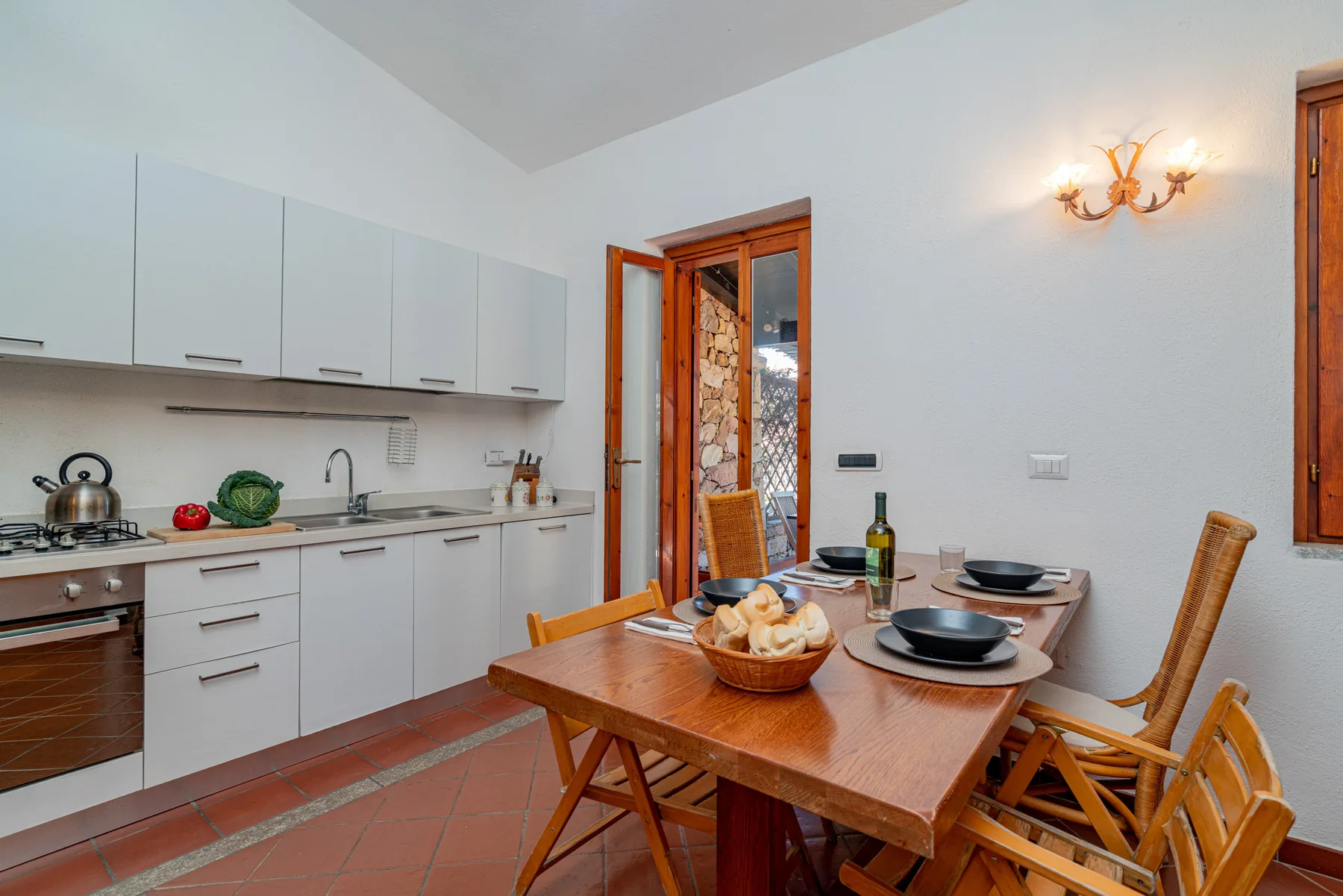 Una cocina y comedor con armarios blancos y una mesa de madera.