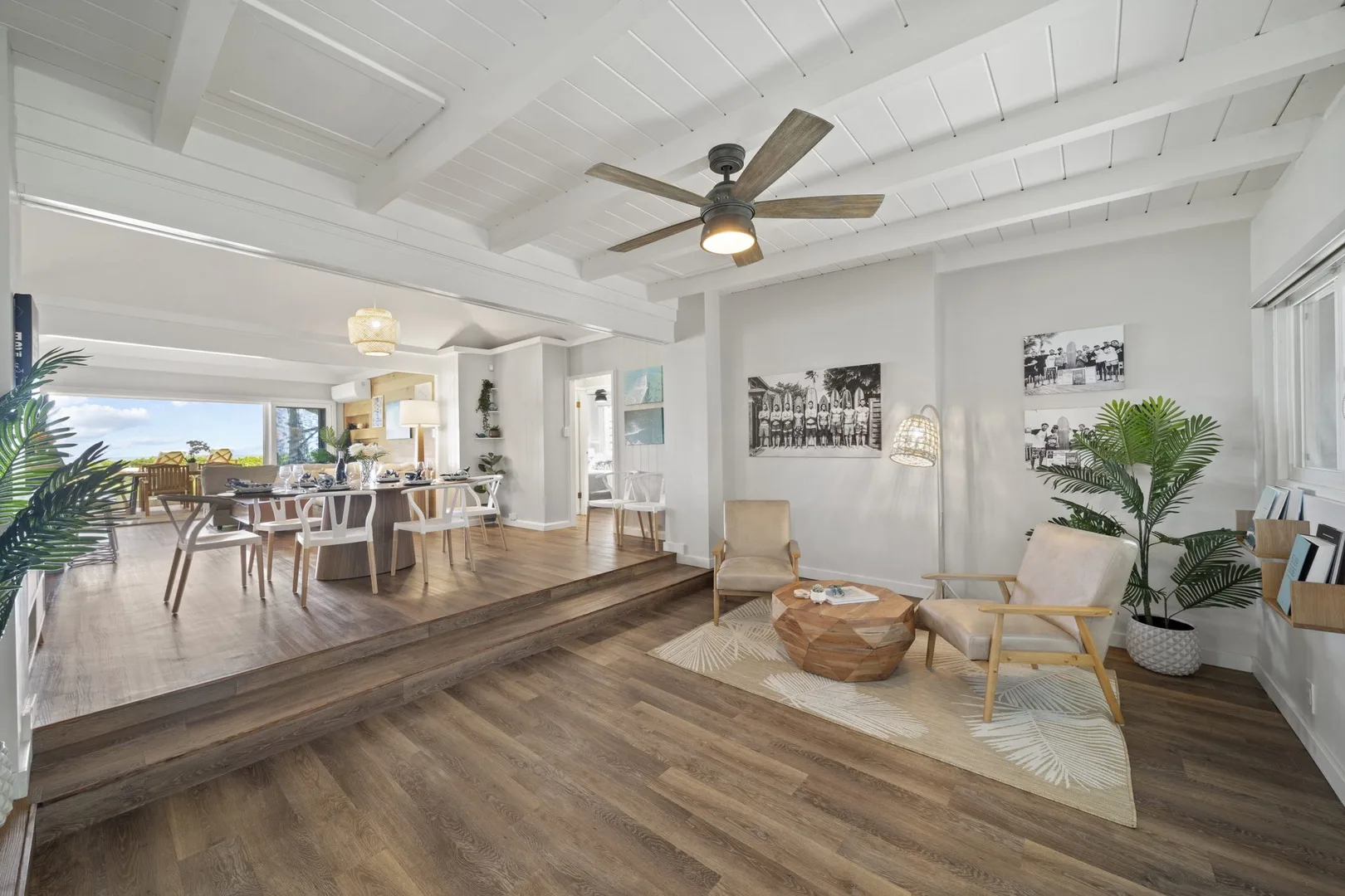 Una luminosa sala-comedor diáfana con asientos y una zona de comedor elevada.