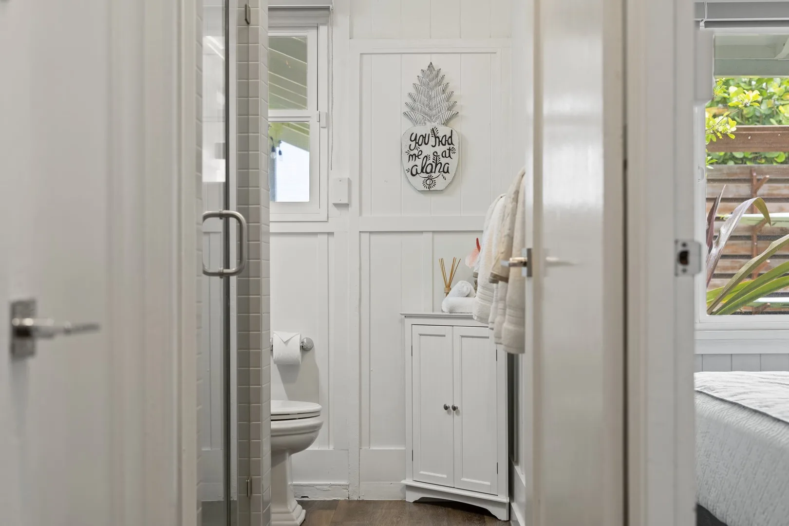 Un baño luminoso con ducha de vidrio, inodoro y tocador blanco.