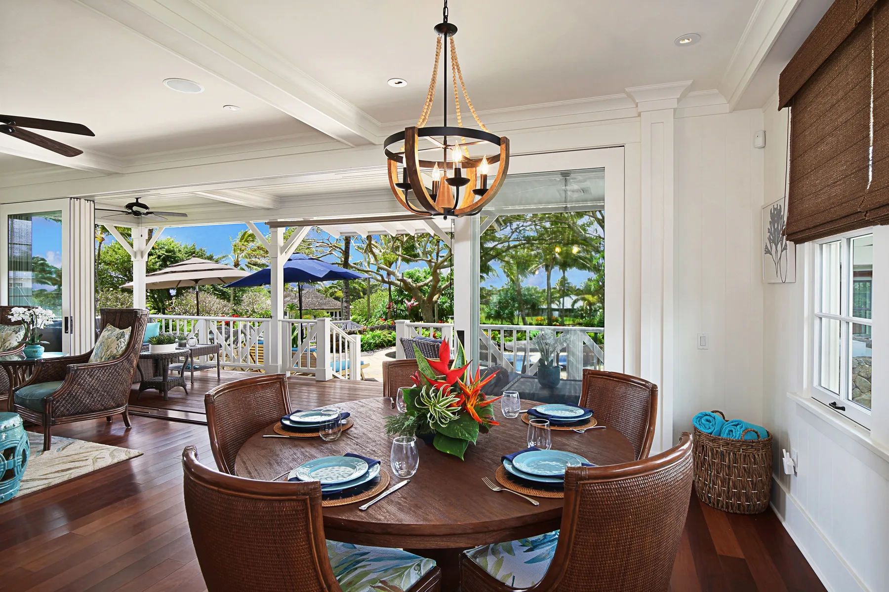 A dining area opens onto a covered patio, with a table set for a meal.