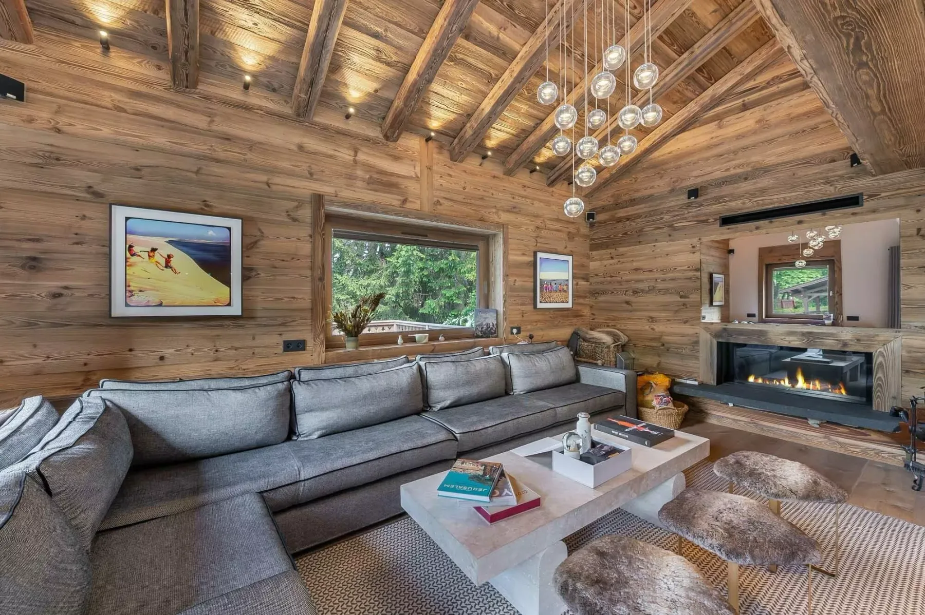 Una sala de estar revestida de madera con un sofá seccional grande y una chimenea.