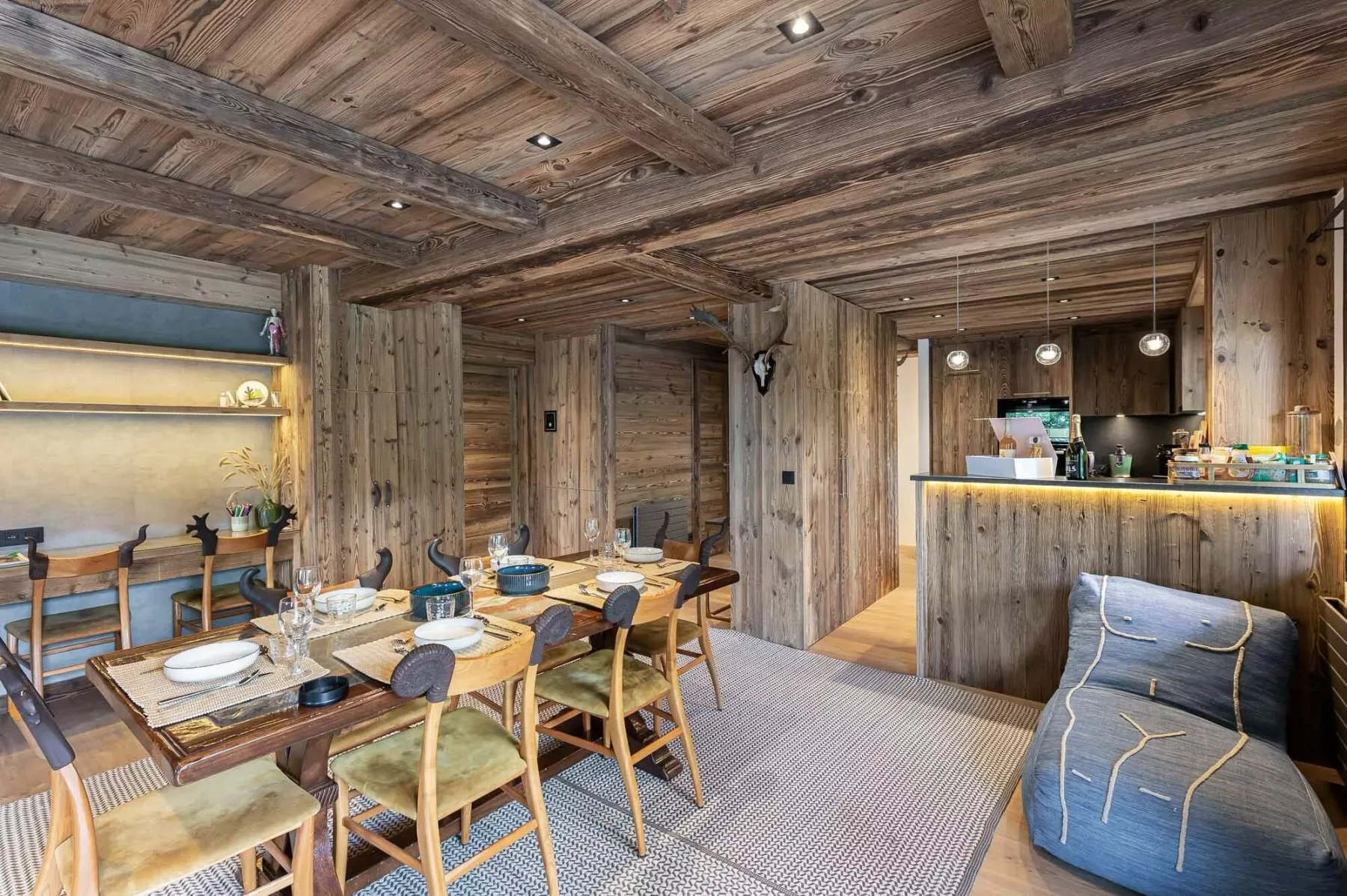 Comedor rústico con una mesa larga y una barra al fondo.