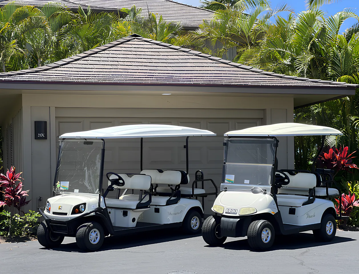 Dos carritos de golf están estacionados frente a un edificio rodeado de vegetación tropical.