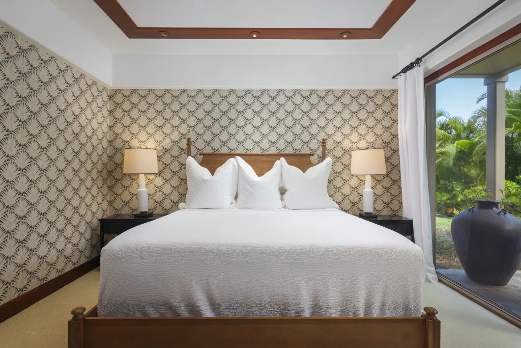 Un dormitorio con una cama grande y papel tapiz estampado.