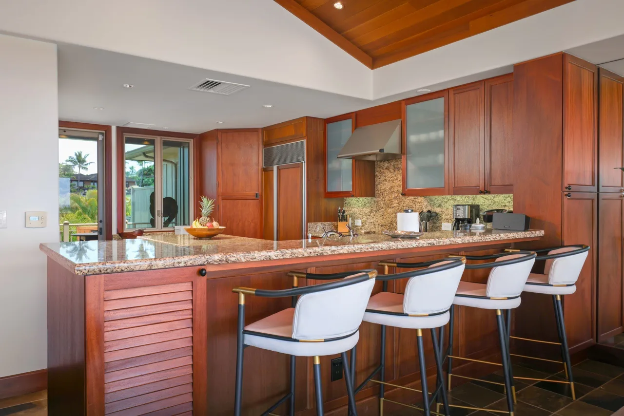 Una cocina con una barra larga y asientos junto a la isla.
