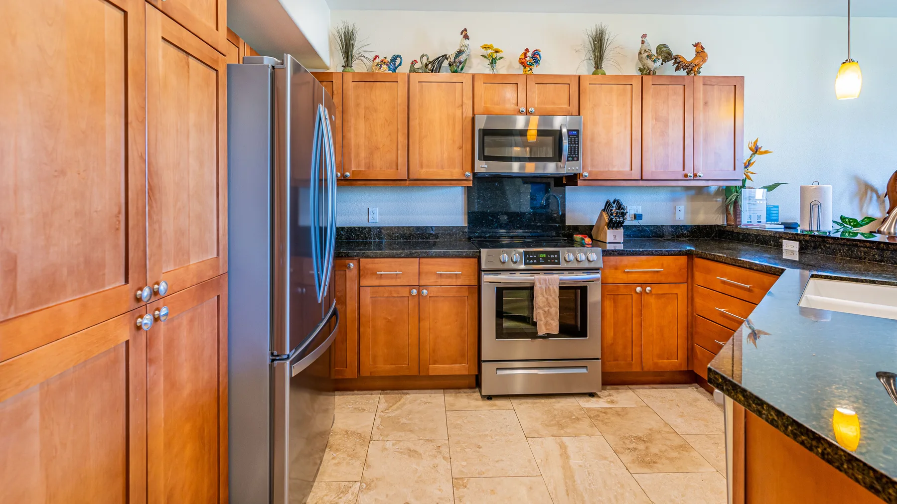 A kitchen with wooden cabinets, a refrigerator, and a stove.