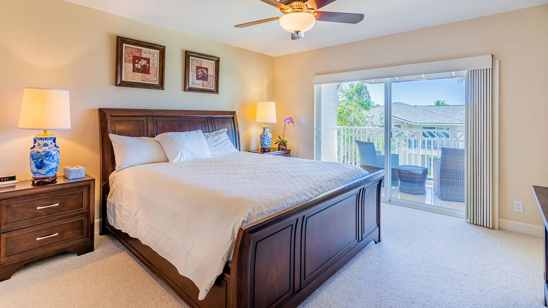 A bedroom with a large bed and sliding glass doors opening onto a balcony.