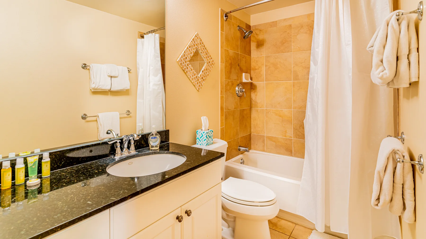 A bathroom with a sink vanity beside a bathtub and shower.