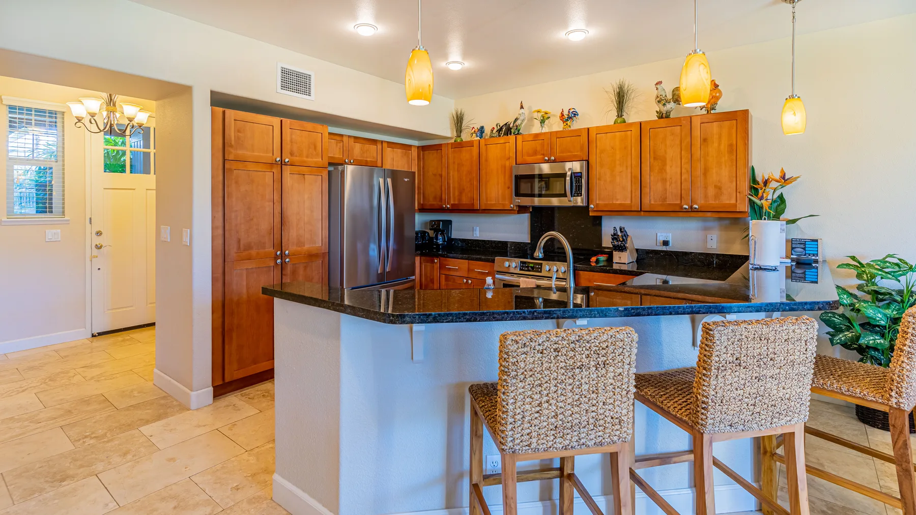 A kitchen with wooden cabinetry, a central island, and bar seating.