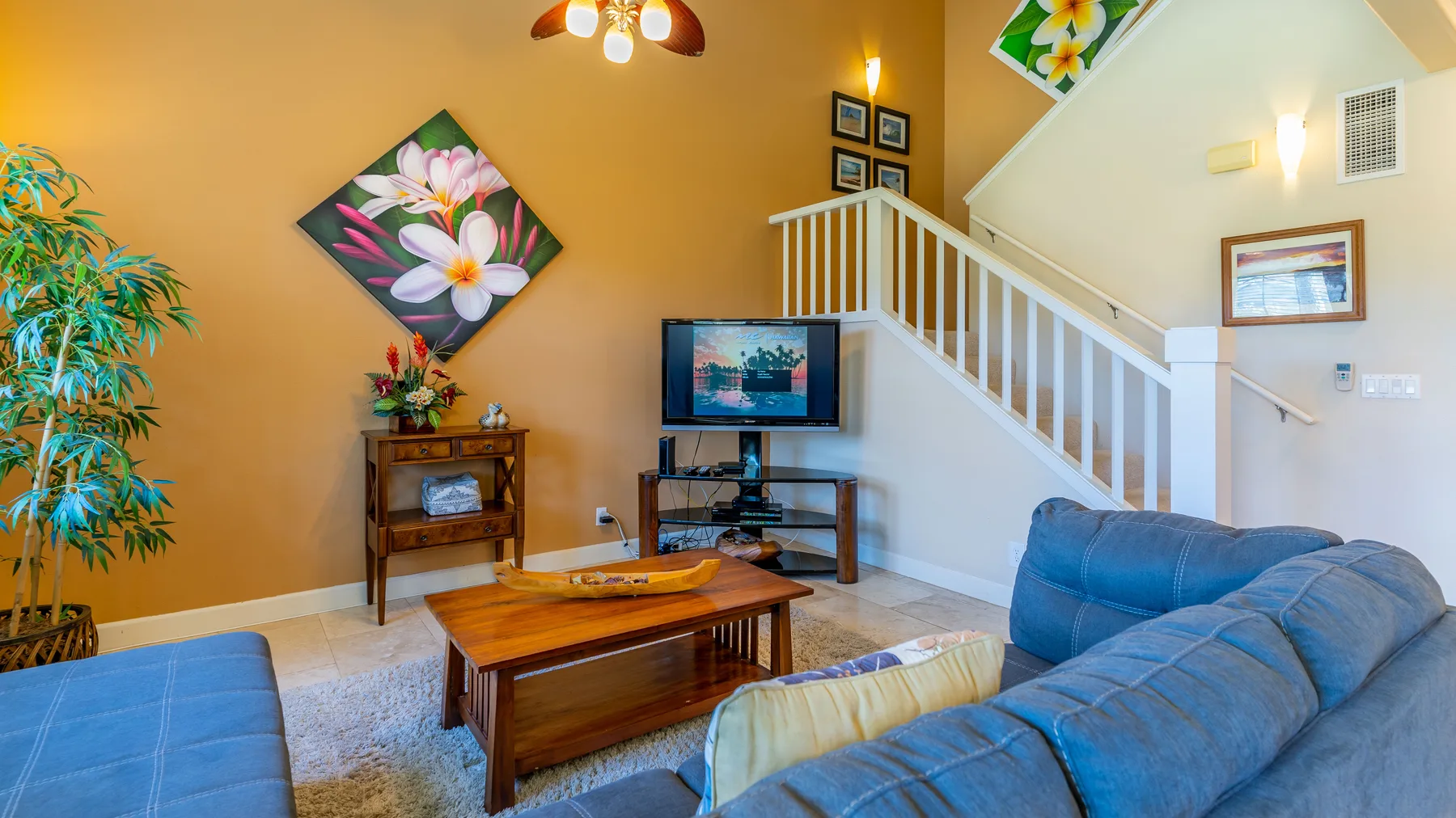 A living room with a television, seating, and a staircase.
