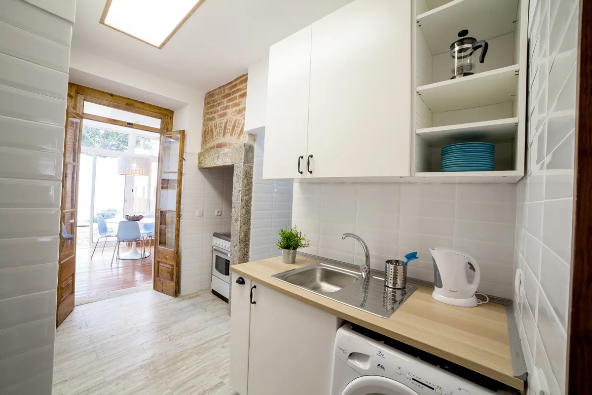A compact kitchen with a sink, cooktop, and washing machine.
