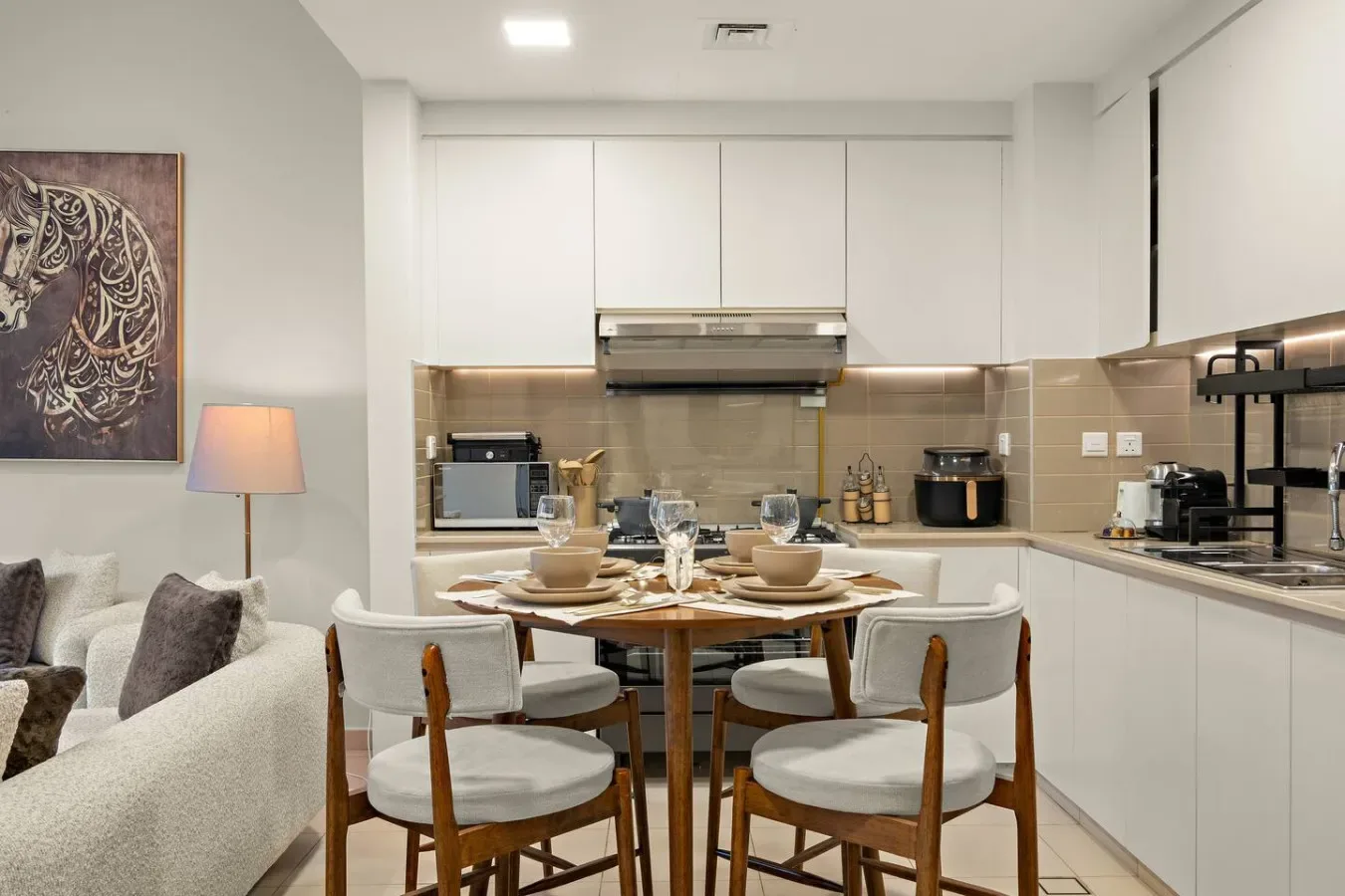A dining area with a set table beside a living room seating area.
