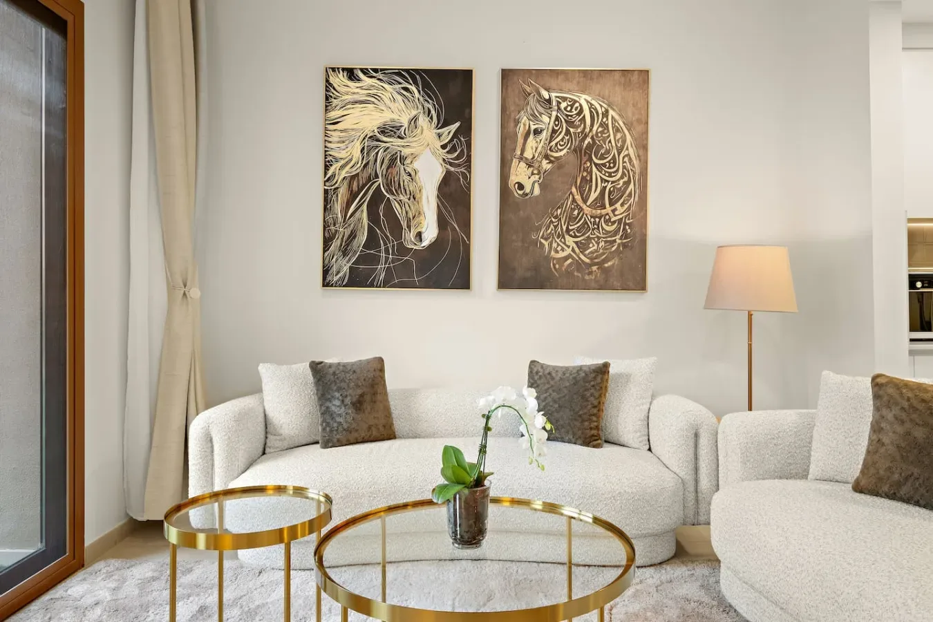 A bright living room with light-colored seating and horse artwork on the wall.